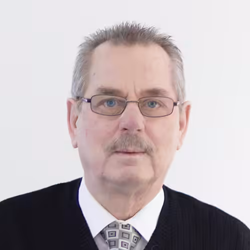 Portrait eines älteren Mannes mit Brille und Krawatte.