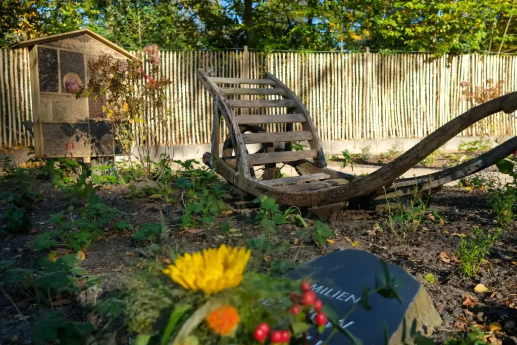 Alter Schlitten im Garten neben Insektenhotel