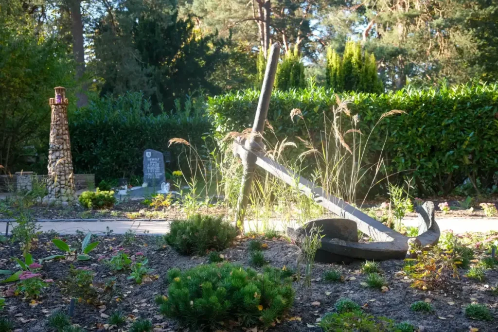 Verlassenes Ankerdenkmal im Garten mit Grabstein