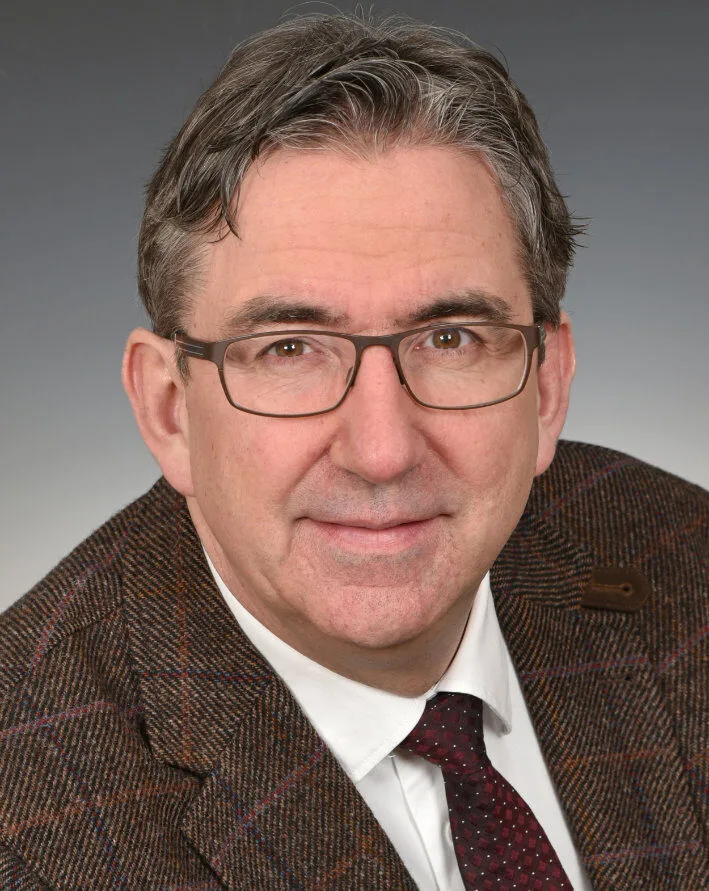 Mann mit Brille in Anzug und Krawatte