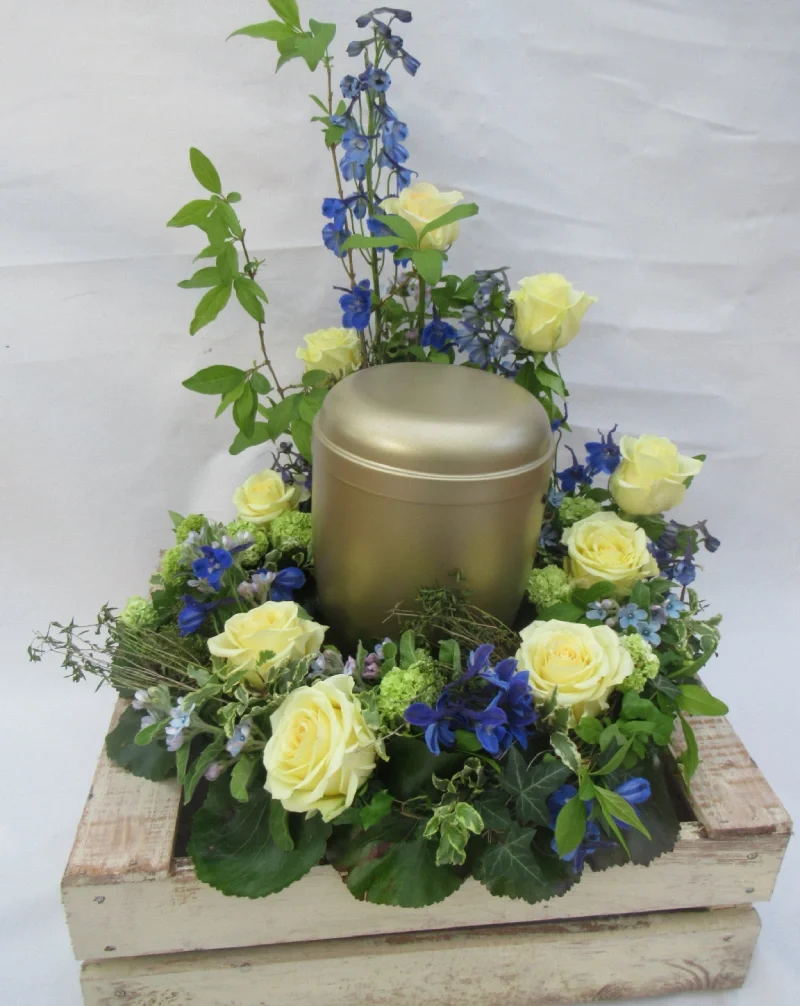 Goldene Urne in Blumenarrangement