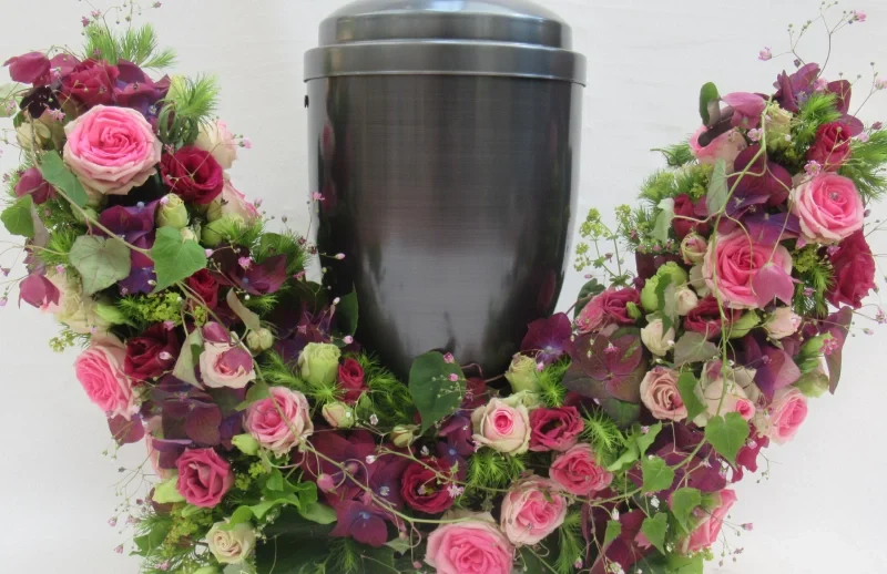 Urne mit Blumengesteck aus Rosen.