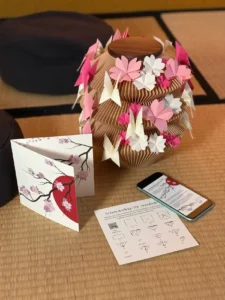 Holzurne mit Kirschblüten aus Papier und passender Karte dazu