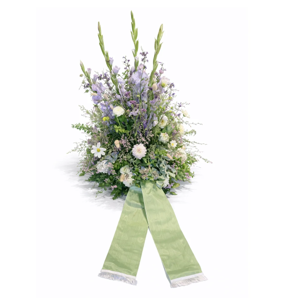 Trauerkranz mit lila und weißen Blumen und grüner Schleife
